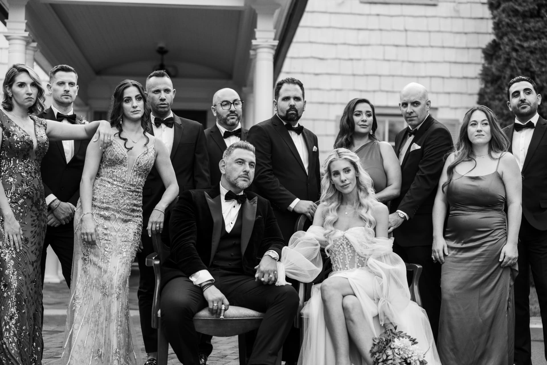 Black-and-white wedding party portrait with the bride and groom seated