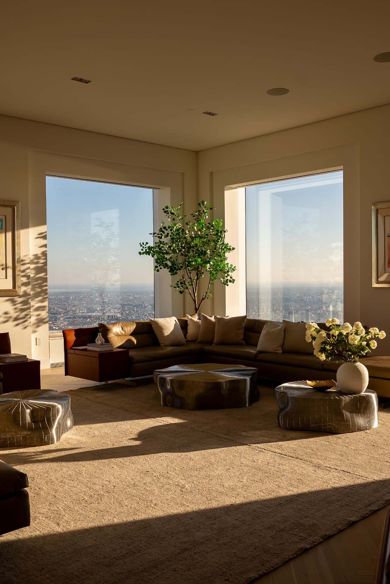 Sunlit penthouse living room with city views