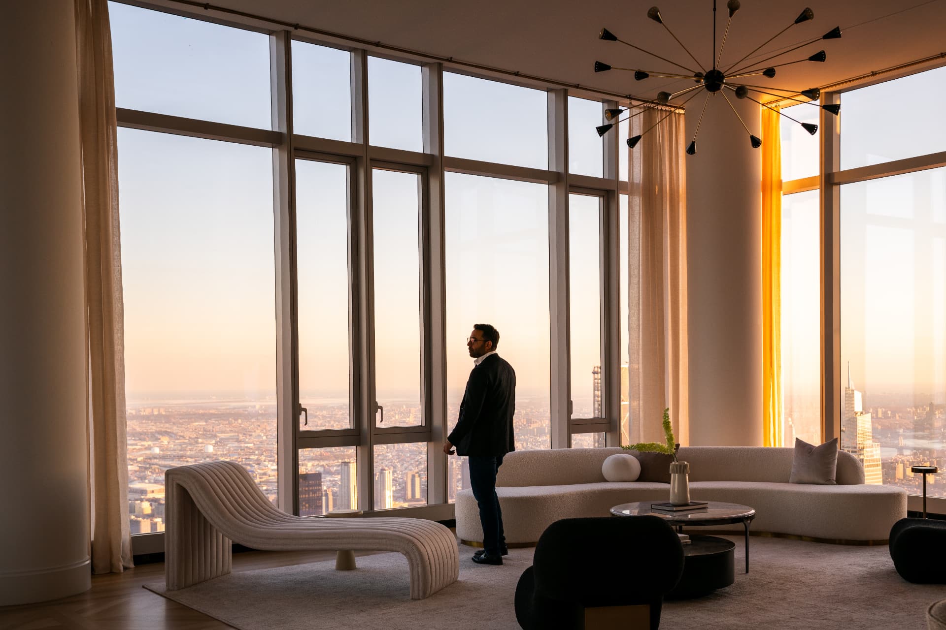 Agent silhouetted against floor-to-ceiling windows at sunset